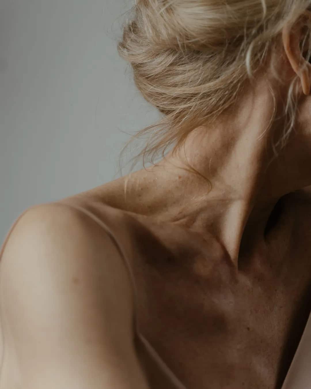 Neck and collarbones of a woman, face turned away